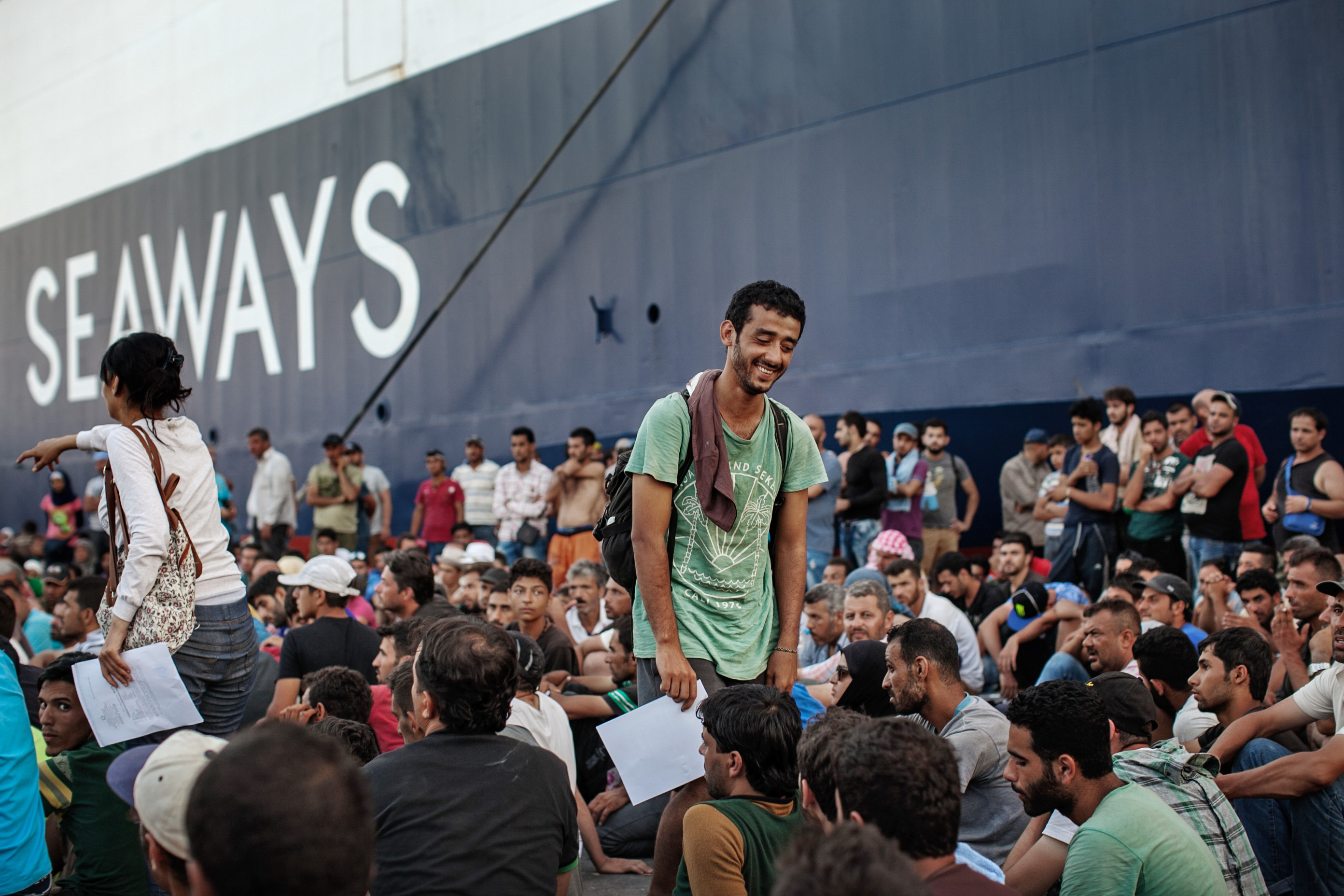 Asaad Sieo, a Syrian military defector, smiled in relief after receiving his legal documents in Lesvos, Greece . Sieo waited in line for three days in order to get processed and receive documents. Many refugees wait for multiple days in line in order to receive legal documents allowing them to travel further into Greece.