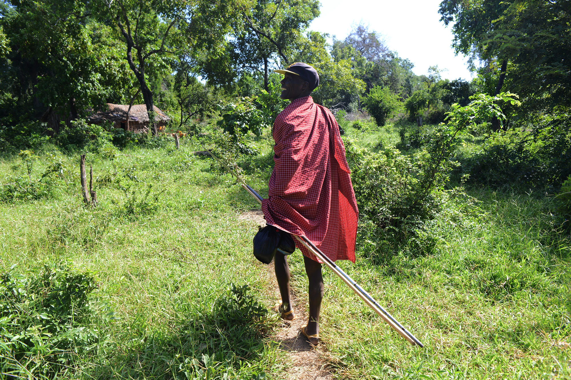 Salumu Kundaya Kidomwita, 60, saunters down a trail to his wife Malinja’s hut. He's on his way back from market day in nearby Nambogo, where multiple tribes meet to sell everything from livestock to maize and cloth. Kiodomwita says he has a lot on his mind, but these thoughts are somewhat quieted by the rainy season – when “the grass is green, it is peace,” he says.