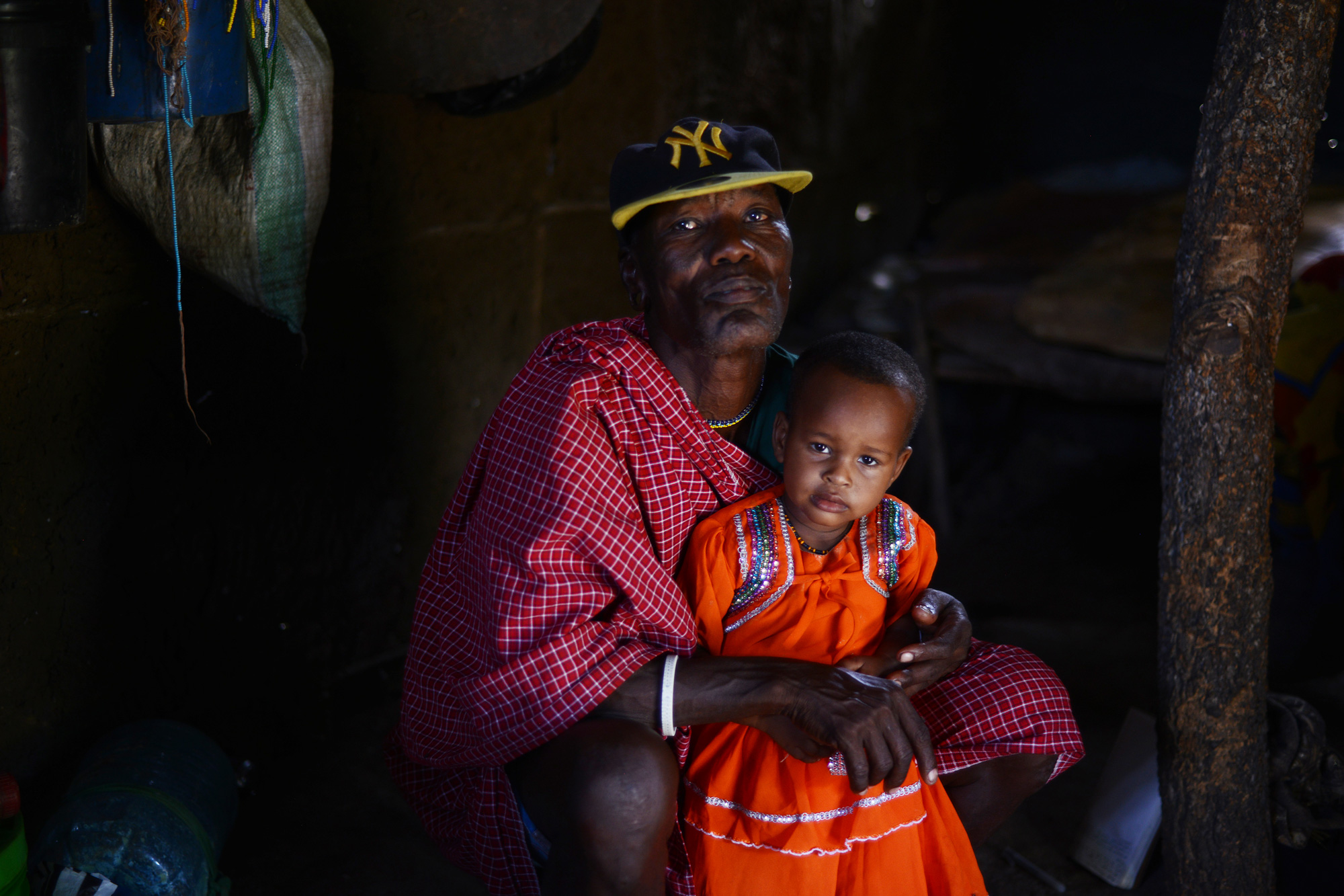 Kidomwita, 60, sits with 2-year-old Mama – the youngest of Kidomwita's 22, going on 23, children.