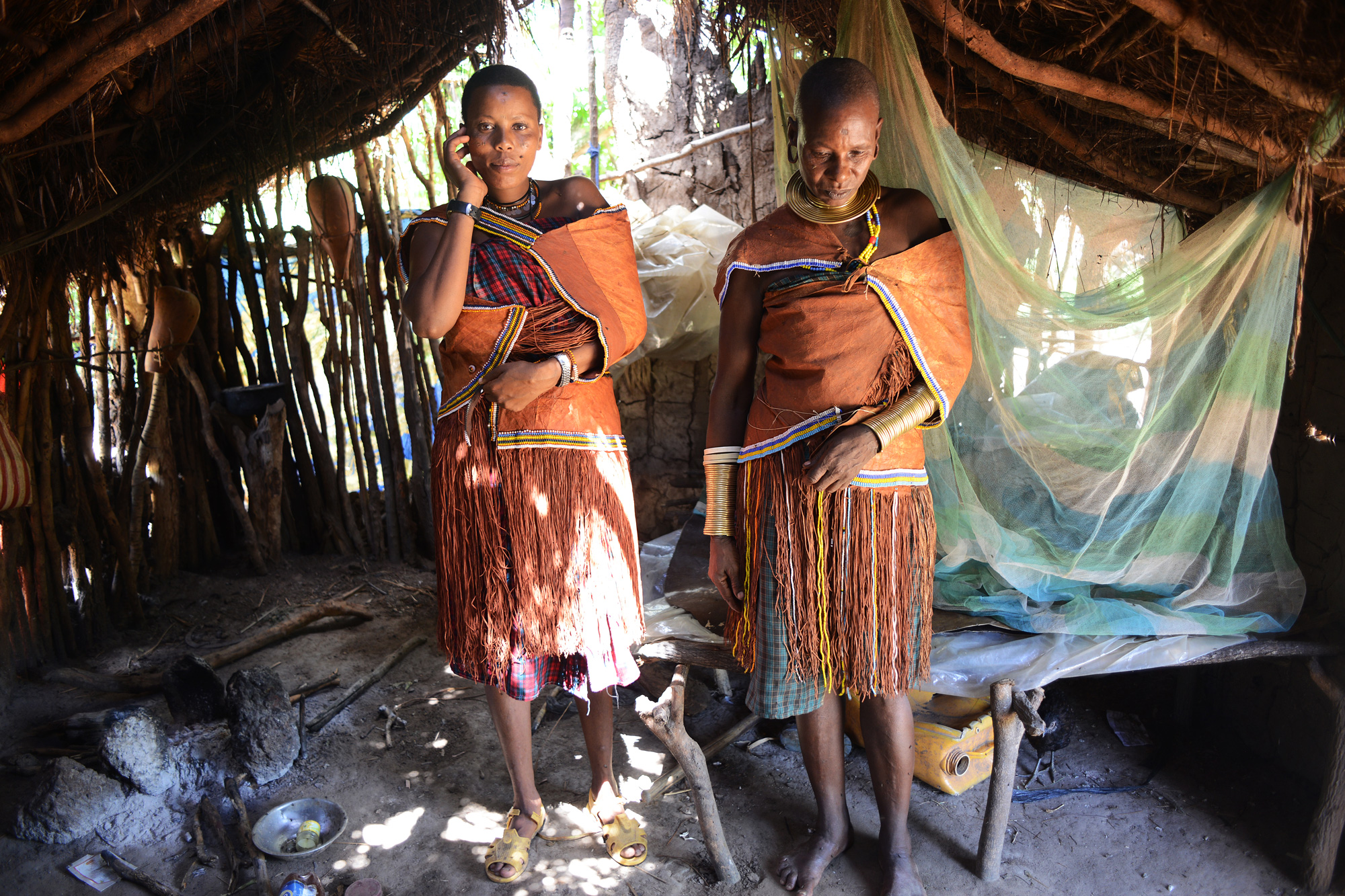 Udenda Gidaghorjod, 20, and her mother, Udangashega Wembida, 40, stand in traditional Barabaig dress at home.