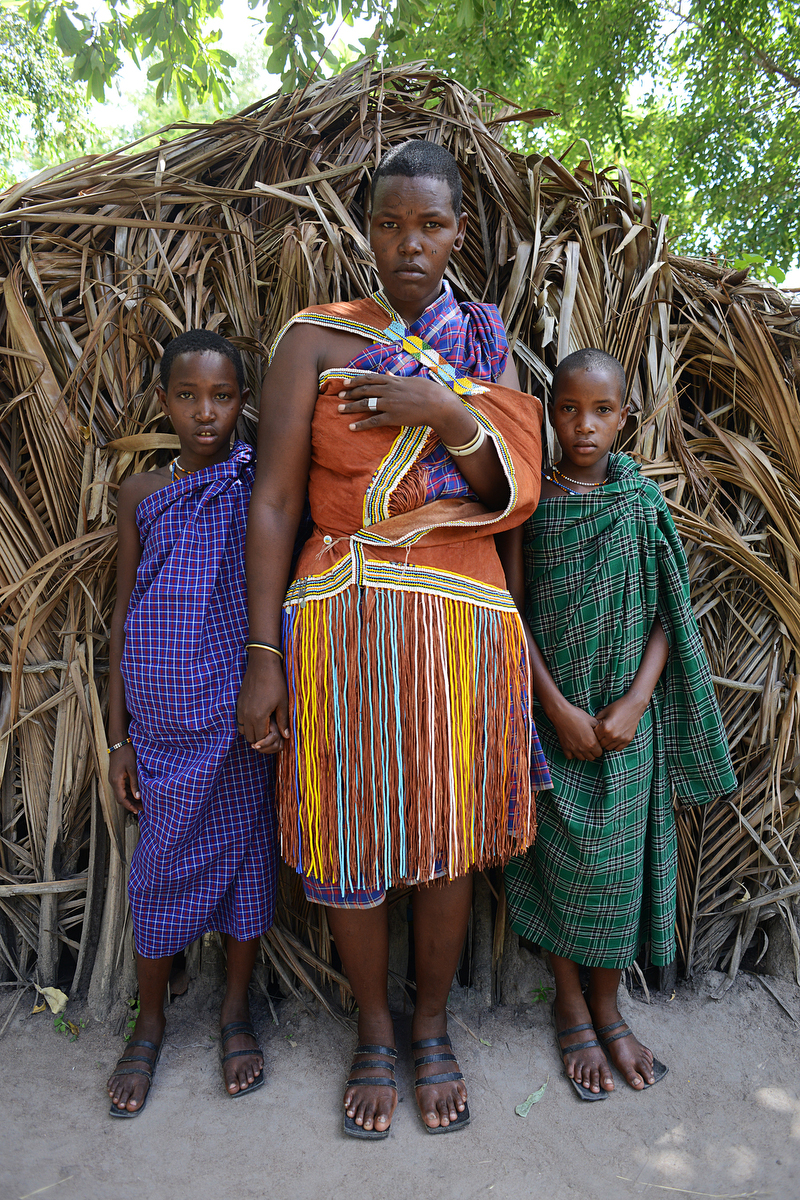 A Barabaig woman poses for a photo with her siblings. According to a report by the International Work Group for Indigenous Affairs, the Barabaig have been targeted for state-sponsored evictions for half a century. "Operation Barabaig," a program designed to permanently settle Barabaig herders, actually forced families from their homes and seized their land for tourism and commercial agriculture.