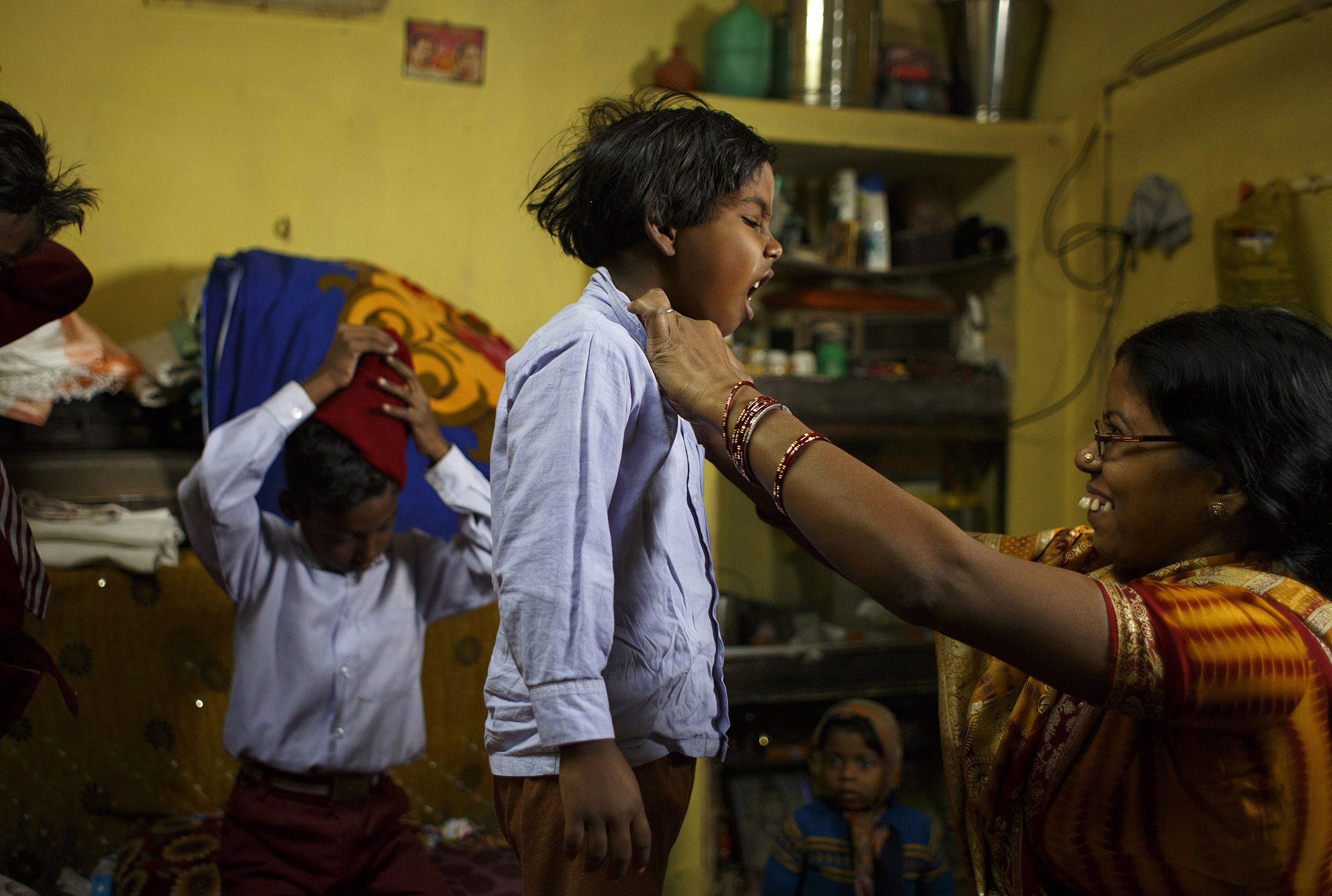 Seema Devi, 33, helps her daughter, Semeran Kumari, 6, remove her school uniform after class at their home in Patna, Bihar. Though she came from a large family, she decided her third child would be her last, and after using a Copper-T IUD for years, she chose to get sterilized. She said it would be difficult for her and her husband to support another child, and to provide their three children with the kind of education they want for them. SARAH WEISER