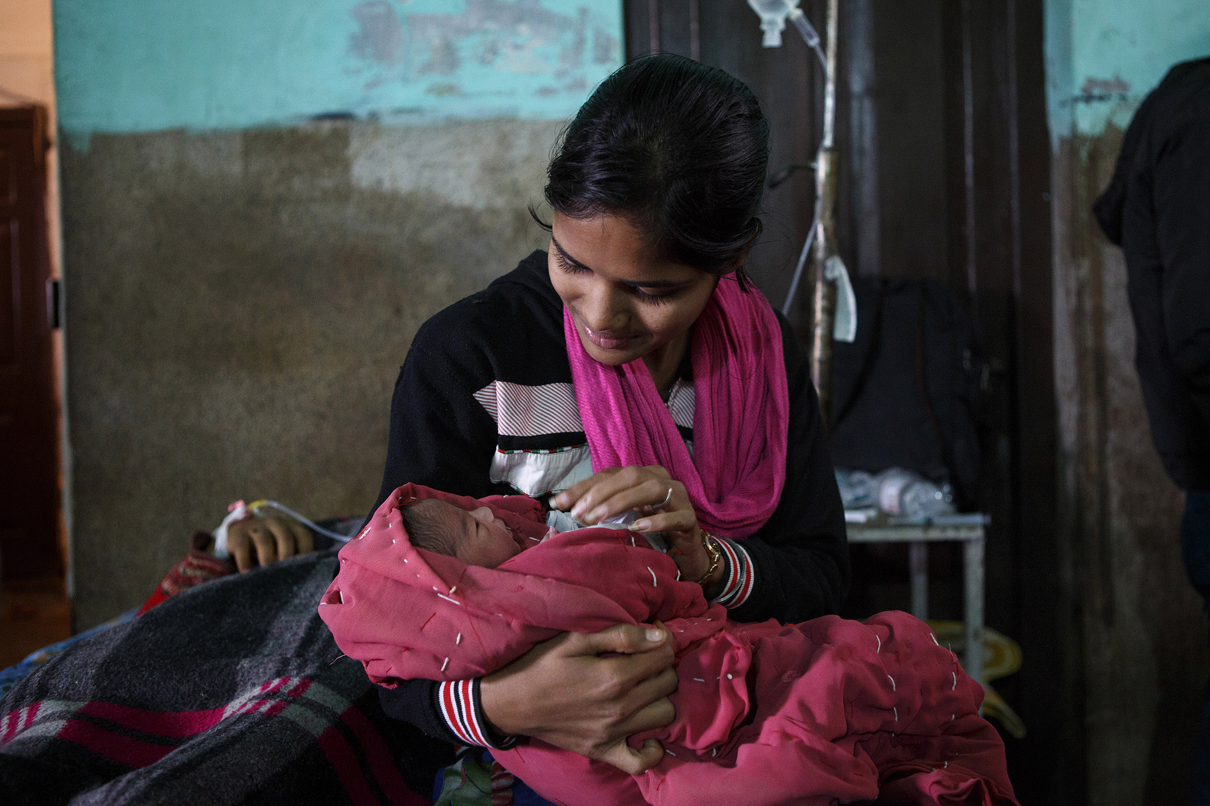 Gurrai Kumari, 18, holds her newborn niece, as the babyÕs mother, Nisha, 21, rests after delivery at the Darbhanga Medical College Hospital in Bihar.