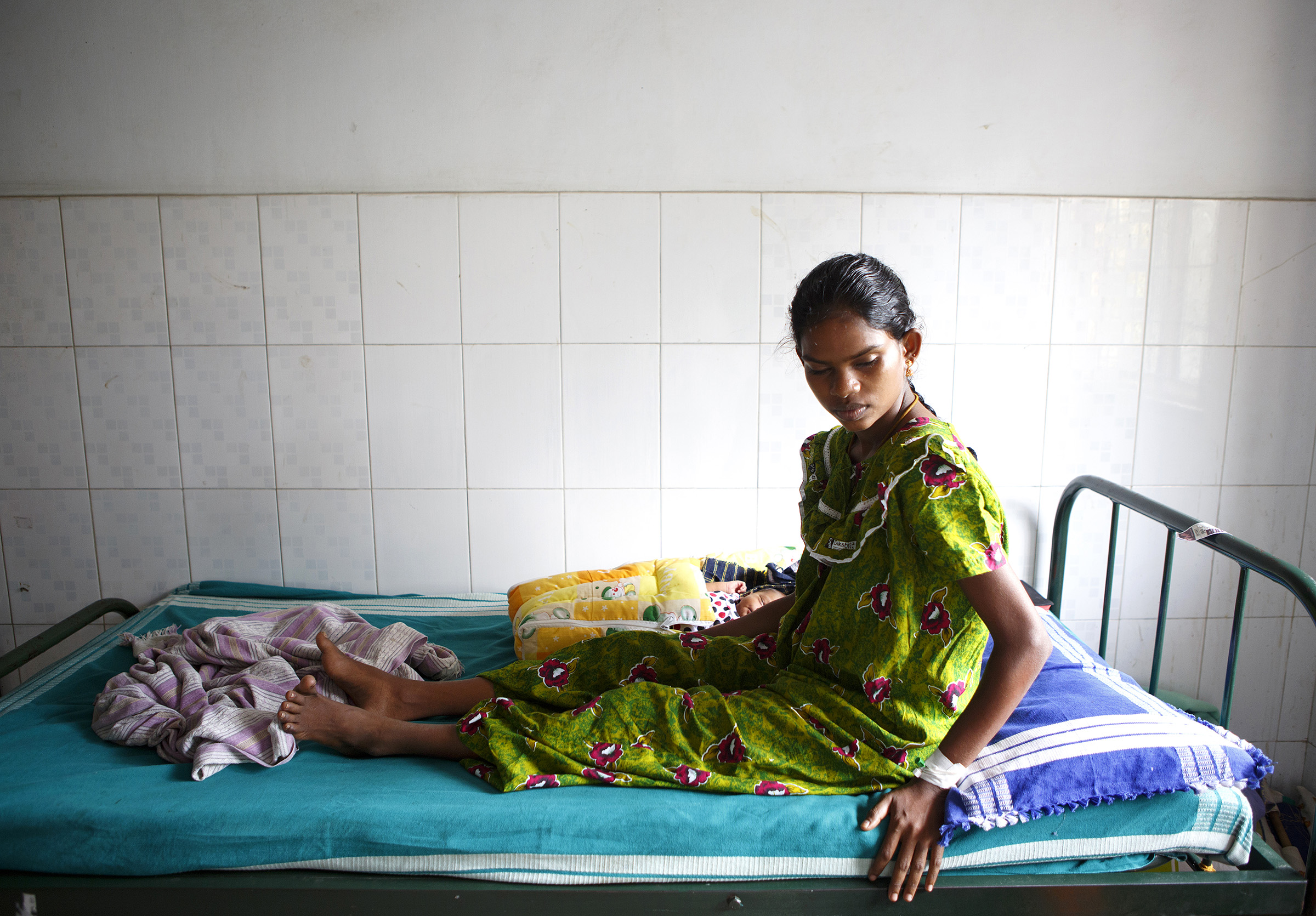 A mother, with her infant beside her, at the Medavakkam Primary Health Centre in Tamil Nadu in December, 2014. SARAH WEISER