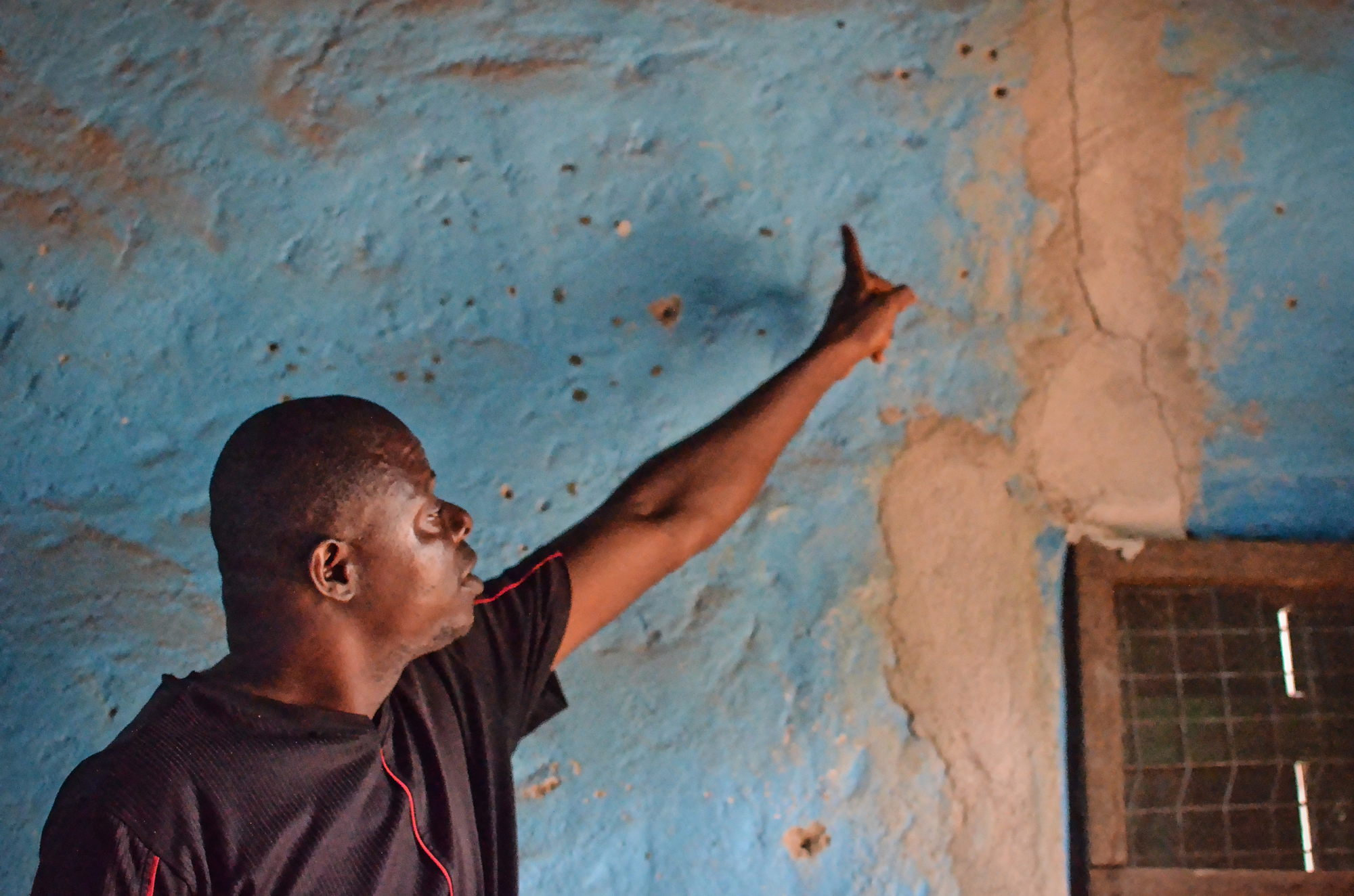 A Koidu resident points out one of the cracks in his house, which he says was caused by vibrations coming from by the mine’s bi-weekly blasts. Many structures in Koidu suffer similar cracks.