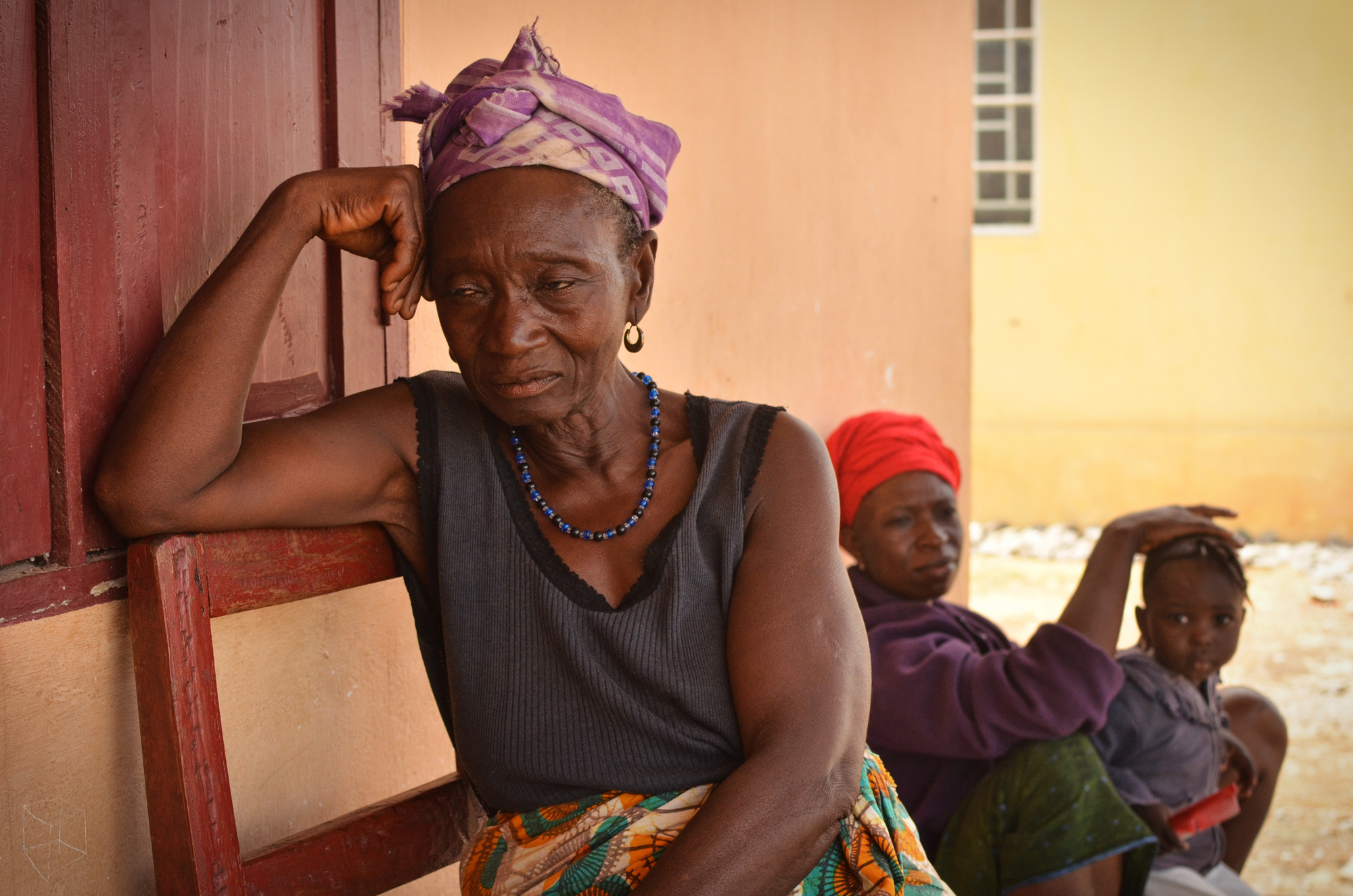 Kumba James, left, and her daughter, Kumba Johnbull, were moved to the resettlement site in 2013, which locals call Benghazi. They say that they are frustrated by limited access to water during the dry season, when the resettlement site’s wells dry up.