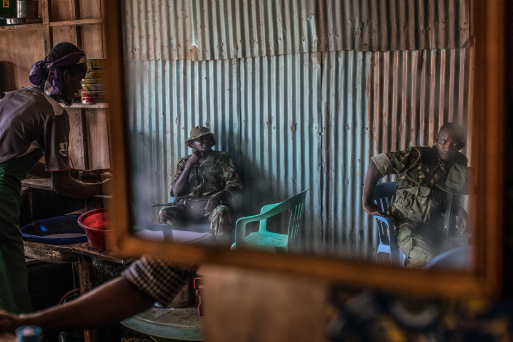 Armed police sit in a cafe in one of Dadaab’s many markets. Rights group have reported strong evidence showing that Kenyan police have carried out extrajudicial killings and enforced disappearances in Dadaab and elsewhere in the country. (Photo by Nichole Sobecki/GroundTruth)