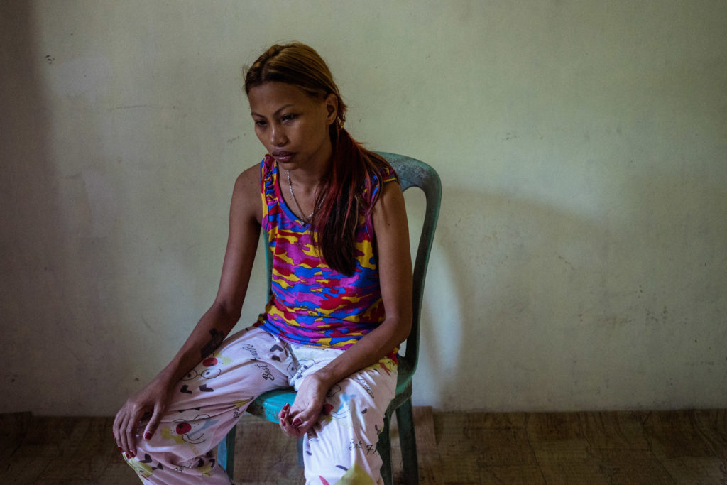 Jojo sits in her house in Angeles City, notorious for its sex tourism and red light district. In the wake of typhoons, women and girls from climate change vulnerable areas, particularly Samar and Leyte, wind up in the sex trade after being displaced from storms. Jojo was trying to leave the sex trade and settle back in Leyte but she was displaced again after Typhoon Haiyan. (Photo by Hannah Reyes Morales/GroundTruth)