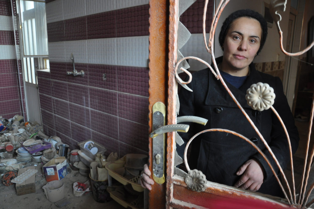 aha Gebo returns to her home after two and a half years to assess the damage. (Photo by Lauren Bohn/GroundTruth)