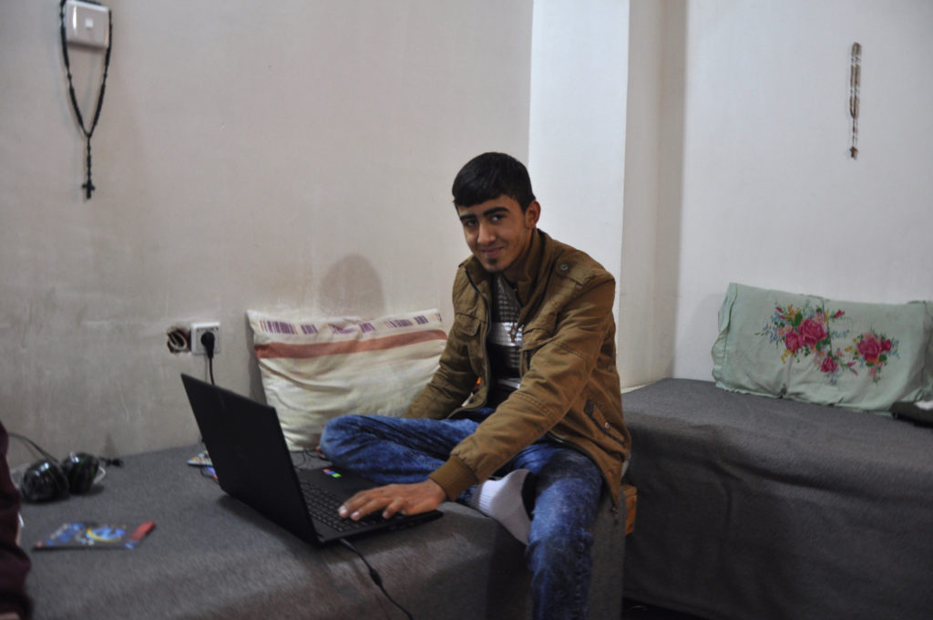 Ismael Al Kanon plays computer games in his room at a Christian charity in Erbil, the capital of Iraq's semiautonomous Kurdish region where many Iraqi Christians have fled. (Photo by Lauren Bohn/GroundTruth)