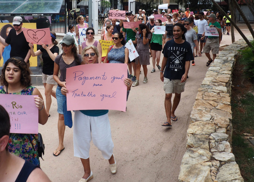 Demonstrators take part in the Women's March on Rio. The sign in the foreground reads "Equal pay for equal work." (Photo by Catherine Osborn/GroundTruth)