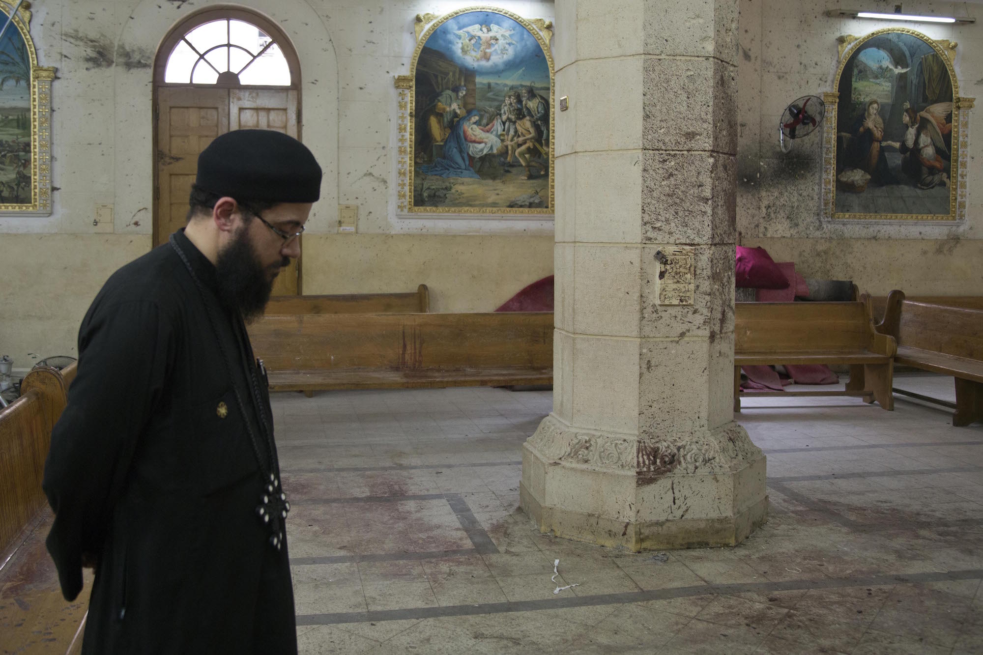 A priest stares at the blood-stained floor of the St George Church in Tanta, Egypt, where a suicide bombing injured and killed dozens of worshippers during the Palm Sunday Mass. Tanta, Egypt, April 12, 2017 (Photo by Roger Anis/GroundTruth)