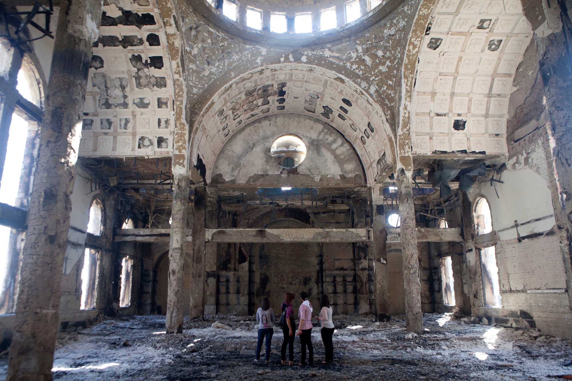 Four women stand in the heavily damaged St. Mousa church in Minya, Egypt, on August 22, 2013. That year, the temple was one of the dozens of churches, businesses and homes that were burned during a surge of violence against Egypt's Christian minority.(Photo by Heidi Levine/Sipa Press).