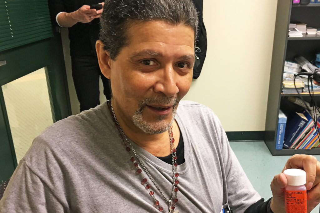 Ivan Flores, 61, holds up his prescription for methadone, which has been keeping him sober after three decades of heroin use. (Photo by Michael O'Brien/GroundTruth)