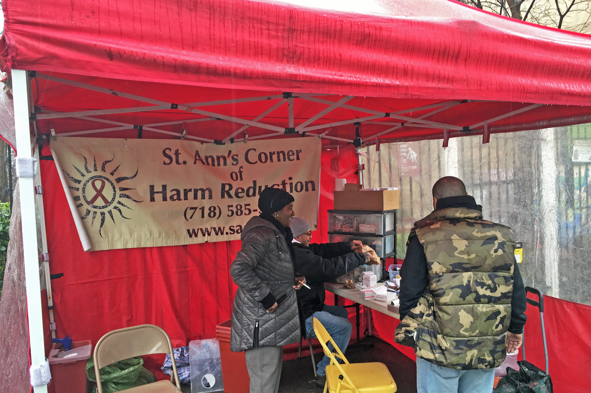 Deborah Walker and Eddie Morales work under the tent at St. Ann's Corner. (Photo by Michael O'Brien/GroundTruth)