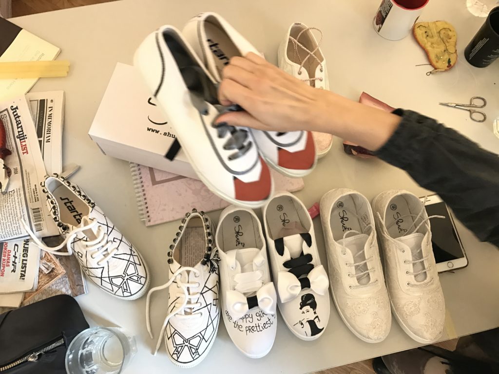 Maja Žirovčić rearranges the hand-painted shoes she's designed with co-founder, Ljudmila Mihajlović. (Photo Credit: Kristina Chorvath)