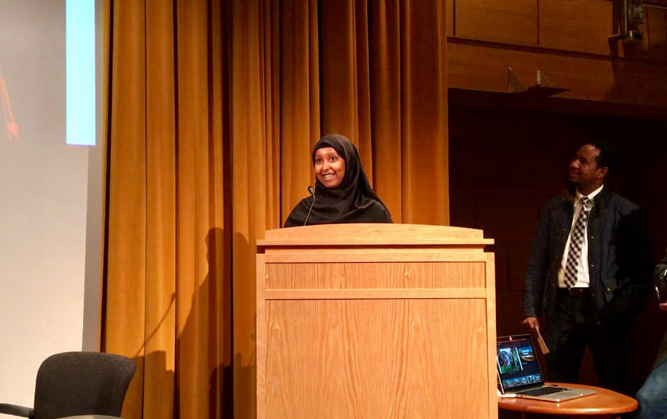 Fowsiya Husein accepts the award for the student photography contest. At right is Abdirahman Mukhtar, youth program manager at the Brian Coyle Center. (Image credit: Gabriel Sanchez)