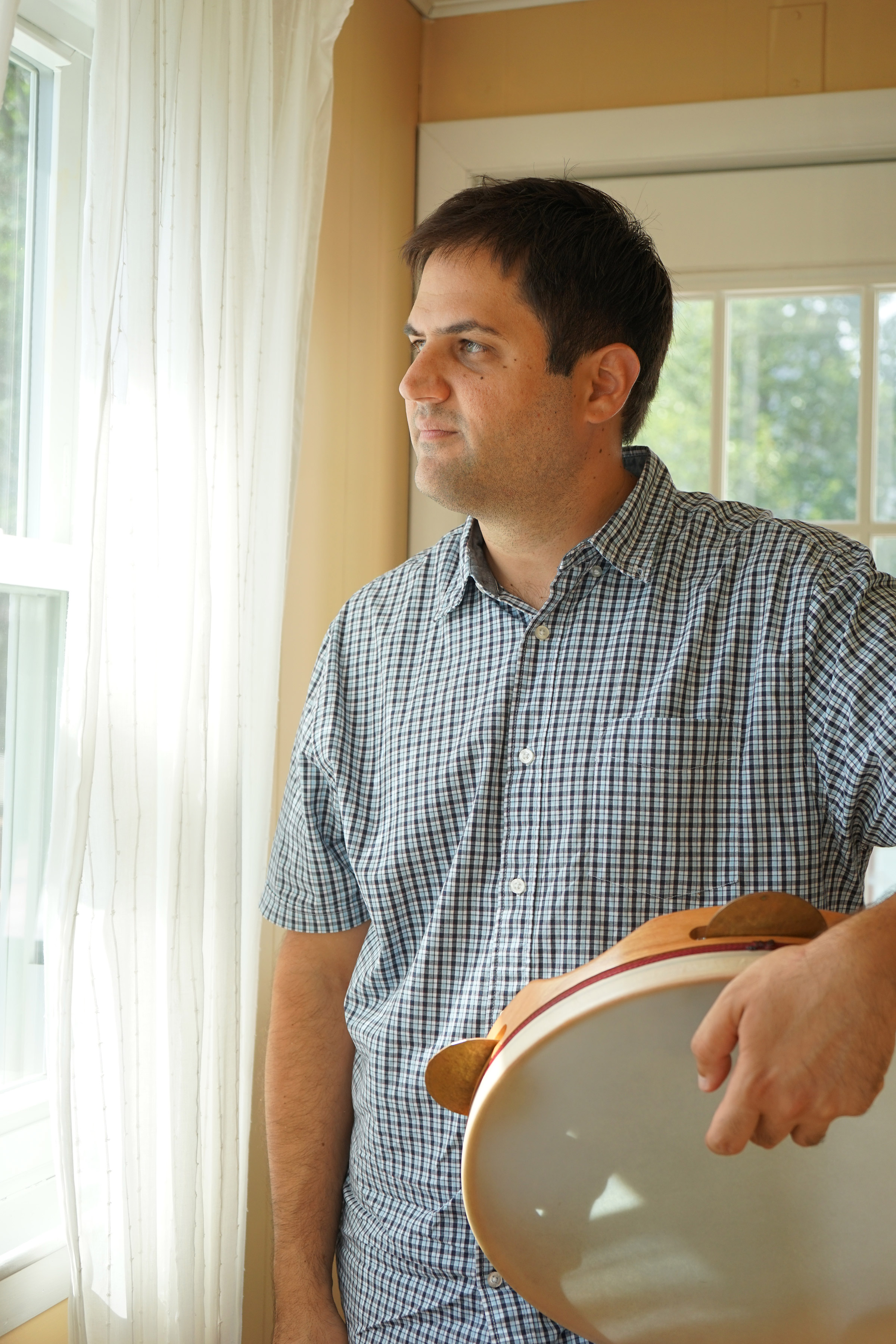 George Lernis holds a bendir, a traditional hand frame drum, used in Middle Eastern and Mediterranean music. (Photo by Heidi Shin)