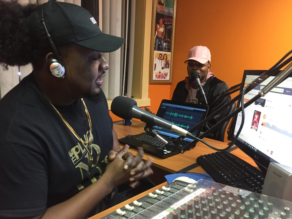 From left, radio host Sanders Nicolas and rapper Masterbrain talk live on air. (Photo by Ian Coss)