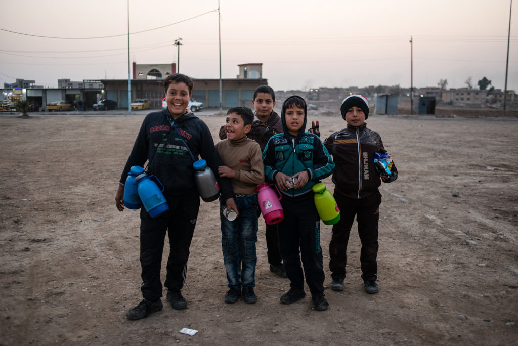 Iraqi children sell tea and biscuits at a traffic intersection at the entrance to West Mosul on January 14, 2018. Though it was a school day, most of the children replied that they had to work to help support their families. (Alex Potter/GroundTruth)