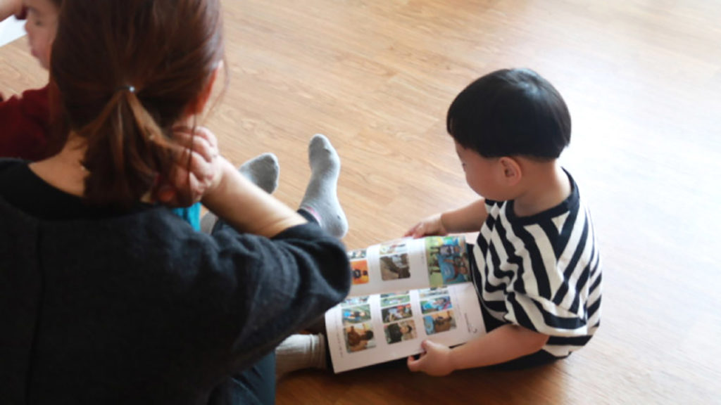 A volunteer reads with an orphan at ShinMang Won Orphanage. (Paulina Cachero/GroundTruth)