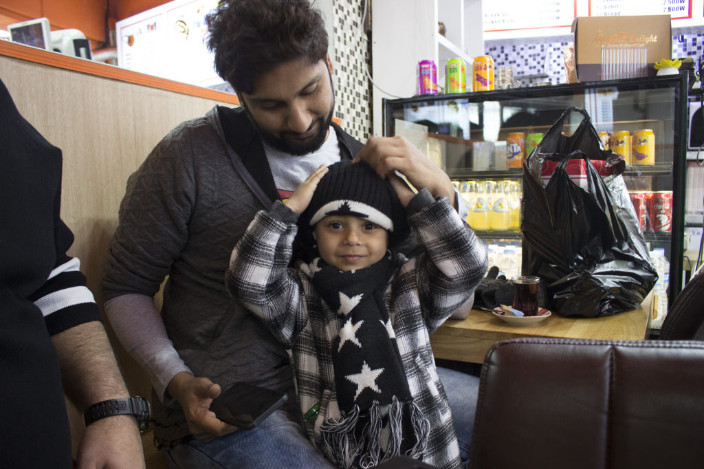 One of the medical tourists and his son enjoy tea and cookies in Istanbul Delight. (Razzan Nakhlawi/GroundTruth)