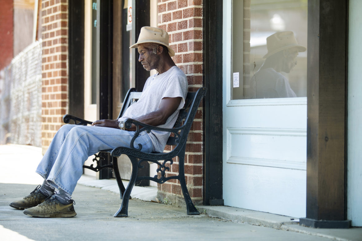 Life-long Utica resident Mack Sears, 68, sits on a bench in the 100 block of West Main Street after leaving Hope Credit Union in Utica Wednesday, June 6, 2018. Utica is about 83 percent African American. Nearly 28 percent of the population lives in poverty.