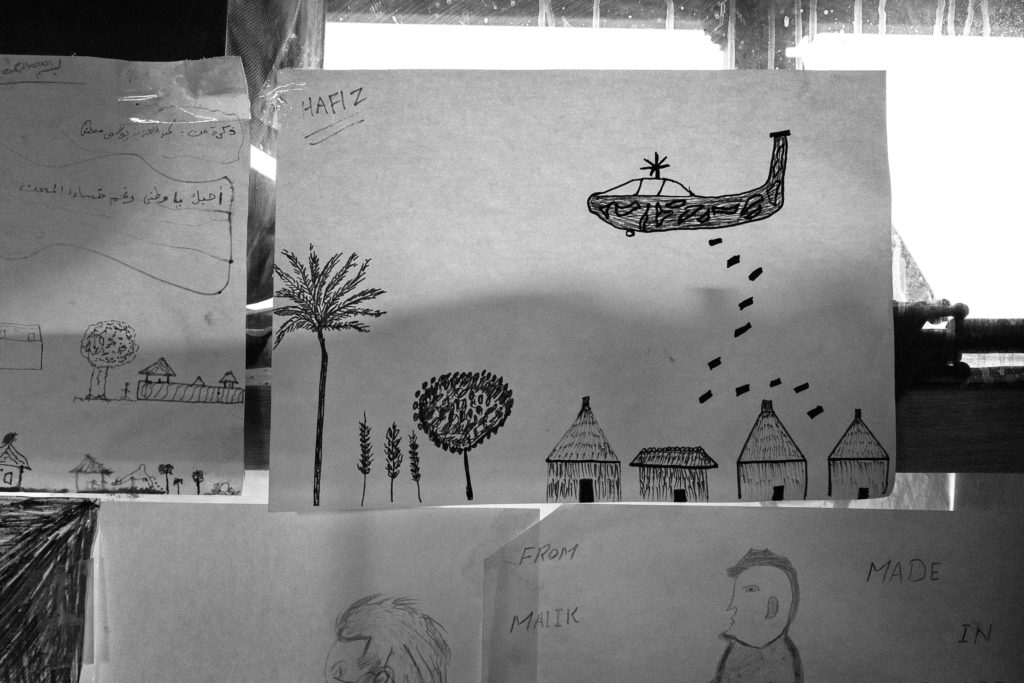 Drawings by workshop participants, children and adults alike, cover the wall and window space of Good Chance's cramped office space in La Bulle. The theater sometimes holds workshops on drawing and other 2D art, but paper and art supplies are nearly always available in the small dome for anyone who wants to draw. (Photo by Annabelle Marcovici/GroundTruth)