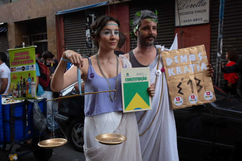 Holding the Brazilian Constitution and a pro-Haddad sign, a couple wears "justice" and "democracy" costumes in a Carnival demonstration against Bolsonaro in São Paulo on October 27, one day before the runoff. The president elect is an open admirer of Brazil’s former military dictatorship. (Photo by José Cícero da Silva/GroundTruth)