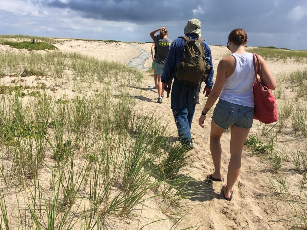 Shannon Hurley leads a couple of teachers from Martha's Vineyard out to the ocean at the Cape Poge Wildlife Refuge on Chappaquiddick, to take them through the field trip portion of a lesson she's put together on climate change. (Photo by Samantha Fields/GroundTruth)