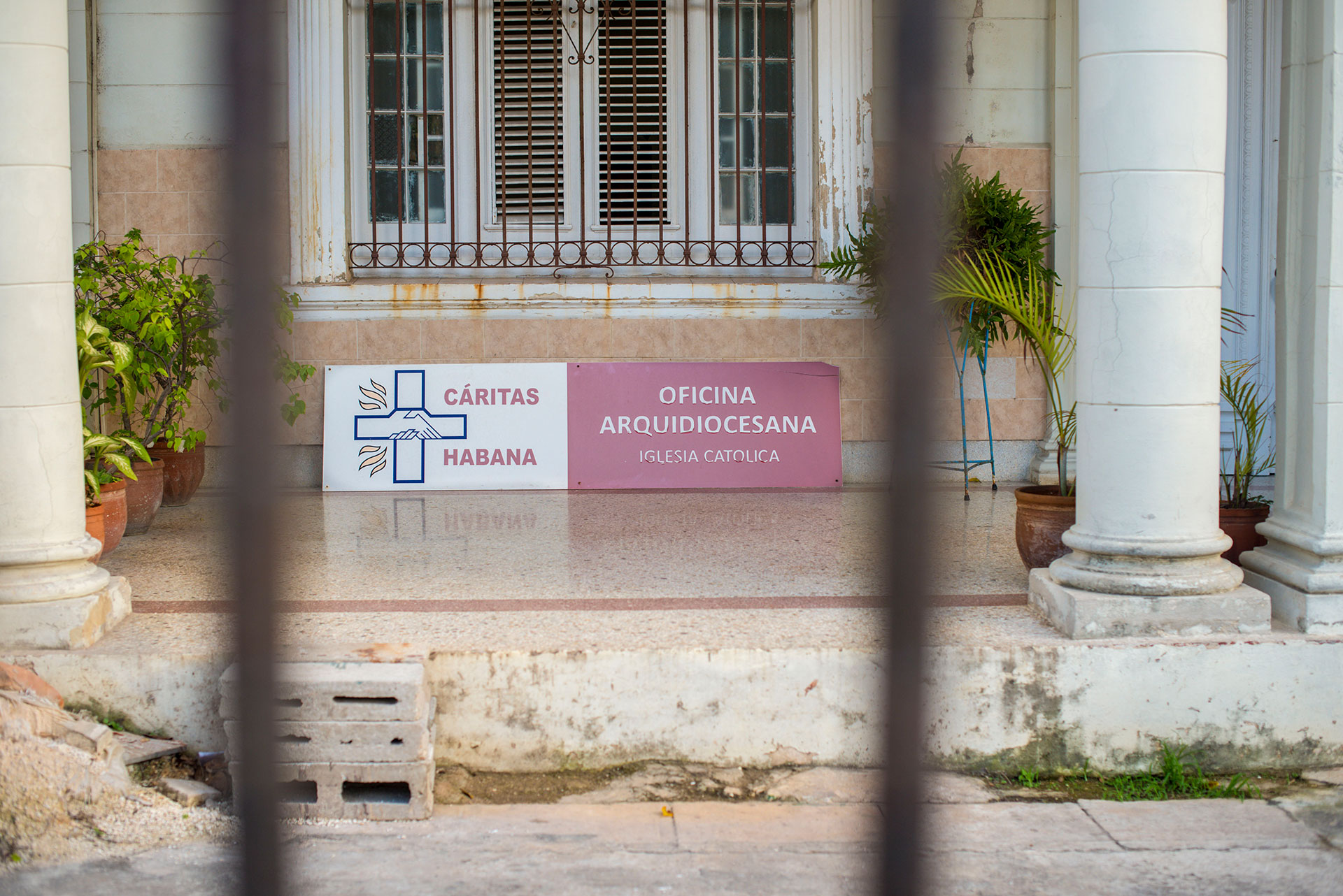 A sign at Caritas Habana is pictured March 7, 2019, in the Vedado neighborhood of Havana, Cuba. Volunteers in Boston, Massachusetts, provide a significant amount of funding to its parent organization, Caritas Cubana, which provides community-based programs and aid throughout the country. (Photo by Estelle De Zan/GroundTruth)