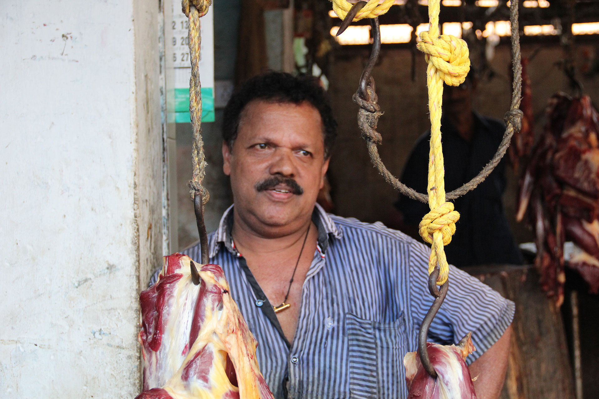 P.K. Radeesh, a 57-year-old butcher stall manager, is a practicing Hindu but supports the Communist Party. (Photo by Diana Kruzman/GroundTruth)